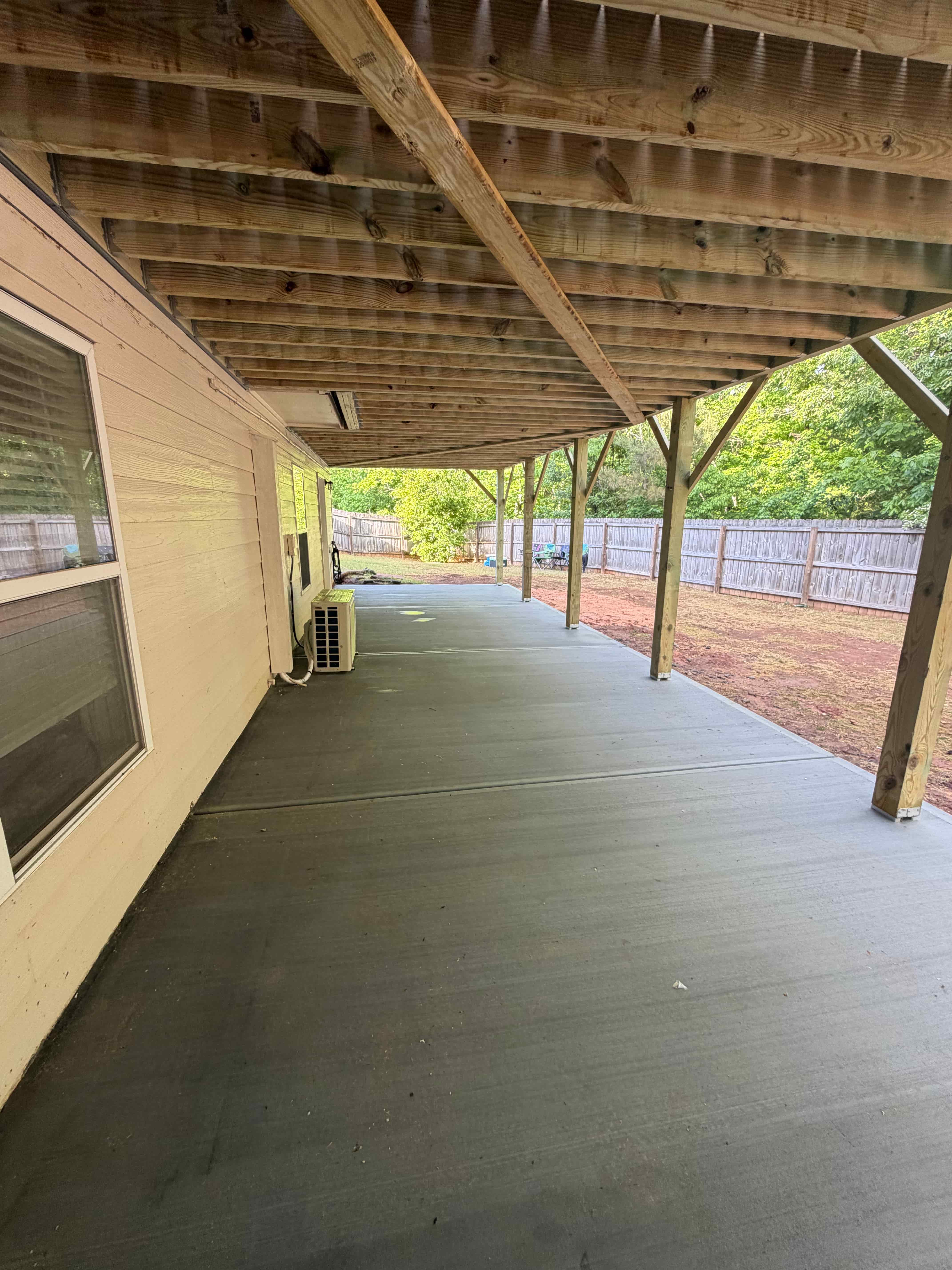 Finished concrete patio under an elevated deck, poured in favorable end-of-summer conditions in Atlanta